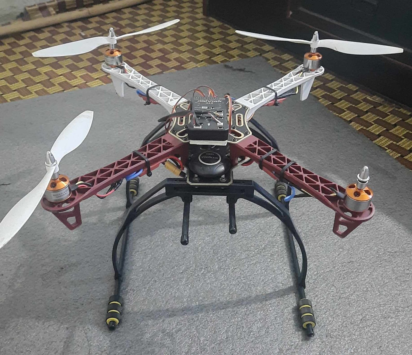 Quadcopter with Pixhawk flight board on a red and white frame